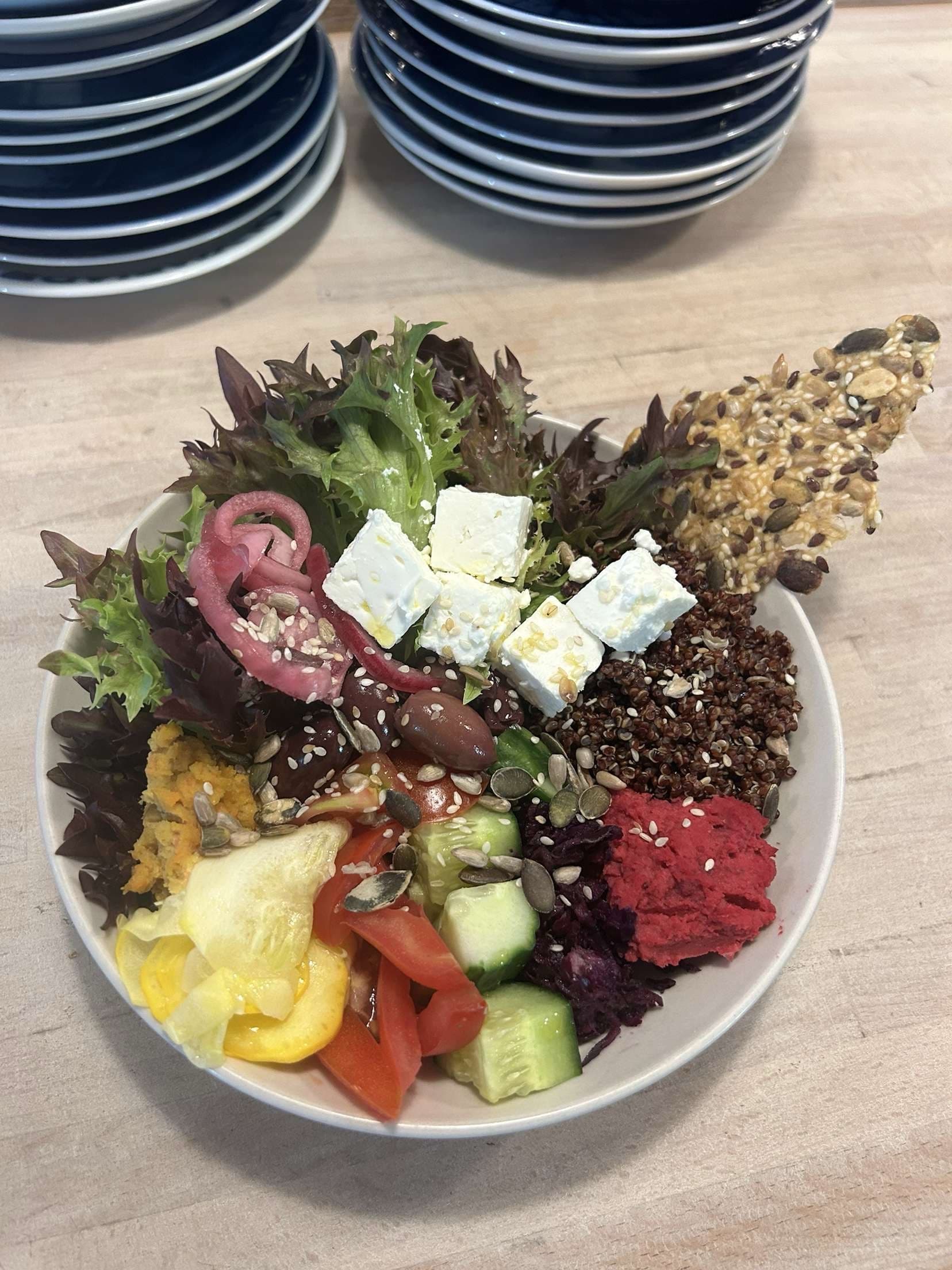 Matig salladsbowl serverad med fetaost, hummus och fröknäcke.