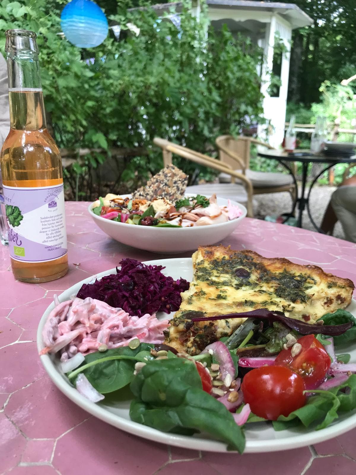 Vegetarisk paj serverad med en varierad sallad och rabarberdryck.